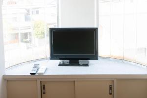 um monitor de computador sentado numa secretária em frente a uma janela em Dazaifu - Apartment / Vacation STAY 36947 em Dazaifu