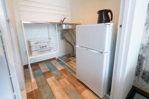 a refrigerator in a small kitchen with a wooden floor at Dazaifu - Apartment / Vacation STAY 36901 in Dazaifu