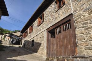 an old stone building with a wooden door at La Casa de Sabina in Lon