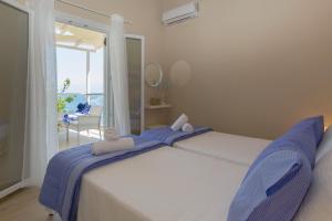 Schlafzimmer mit einem Bett und Meerblick in der Unterkunft Alisachni Apartments in Apraos