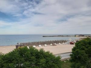 a beach with chairs and umbrellas and the ocean at Apartament Nich in Mangalia