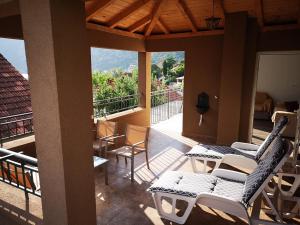 a patio with chairs and tables and a balcony at Apartments Montenegro Risan Čučković in Risan