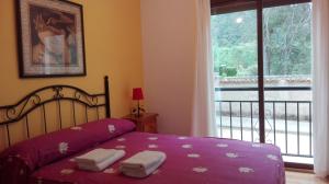 een slaapkamer met een paars bed met handdoeken erop bij EL JABALÍ CONTENTO in Arroyo Frio