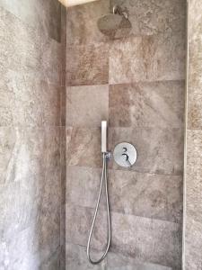 a shower with a shower head in a bathroom at Appartamento deluxe con terrazza sul mare in Savona