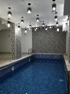 a swimming pool with a blue tiled wall and lights at Weekend Hotel in Aqaba