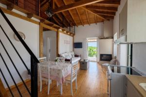 SokrákionにあるKoukoutsa House with Swimming Pool Corfu Sokrakiのテーブルと椅子のあるキッチンとリビングルーム