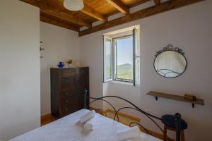 SokrákionにあるKoukoutsa House with Swimming Pool Corfu Sokrakiのベッドと鏡と窓のある寝室 +37枚の写真
