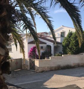 ein weißes Haus mit Palmen davor in der Unterkunft Appartement Mila in Hvar