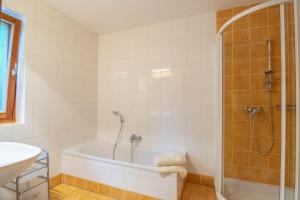 a bathroom with a bath tub and a shower at Urlaubsbauernhof Wabnig in Moosburg