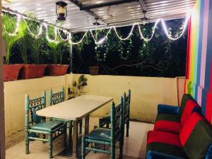 uma mesa e cadeiras num restaurante com plantas em Town Hostel Mumbai - AC Dormitory em Mumbai