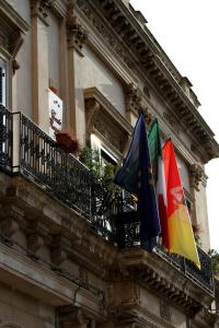 Deux drapeaux sur un balcon d'un bâtiment dans l'établissement B&B Conte Ruggero, à Scicli