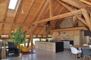 a kitchen and dining room with wooden ceilings and tables at Ferienwohnung Reichart in Lochau