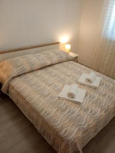 1 dormitorio con 1 cama con 2 toallas en Apartment Maslina, en Bibinje