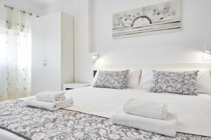 a bedroom with a white bed with towels on it at Sonrisa Apartments in Benidorm