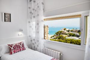 a bedroom with a window with a view of the ocean at Sonrisa Apartments in Benidorm