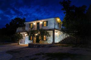 una casa de piedra con luces encendidas por la noche en Villa Anka, en Posedarje