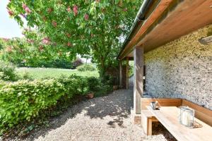 un banco de madera sentado junto a una pared de piedra en Shepherds Barn, en West Dean