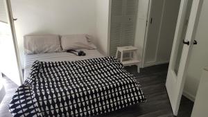 sypialnia z łóżkiem z czarno-białym kocem w obiekcie STUDIO en face de la forêt de FONTAINEBLEAU w mieście Avon