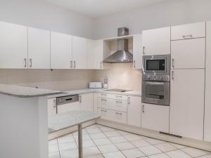 una cucina bianca con armadietti e elettrodomestici bianchi di Chambre cozy et confortable au coeur d'Ajaccio ad Ajaccio