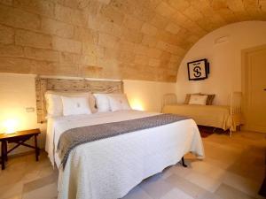 een slaapkamer met een groot bed in een stenen muur bij Suite Sirene in Polignano a Mare