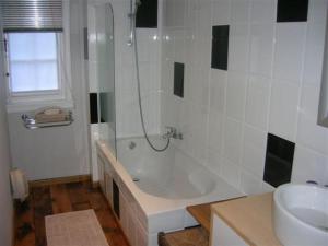 a white bath tub sitting next to a white sink at Hotel Kasteelhof 'T Hooghe in Ieper