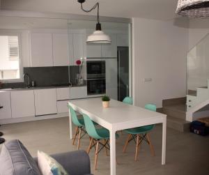 uma cozinha e sala de jantar com uma mesa branca e cadeiras em Los Tilos em Alcossebre