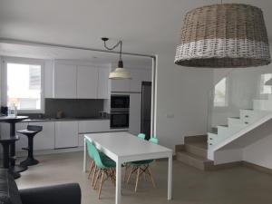 a kitchen and dining room with a white table and chairs at Los Tilos in Alcossebre