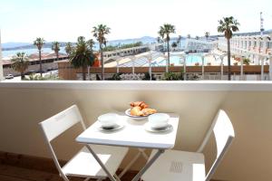a table and chairs with a plate of food on a balcony at Résidence La Corvette in Toulon