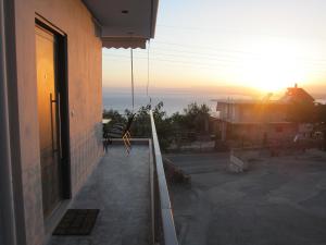 a balcony of a house with the sunset in the background at Blue Yard Apartments in Kalamata