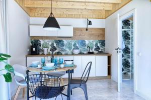 a dining room with a table and chairs in a kitchen at SEI VENTI in Białogóra +21 photos