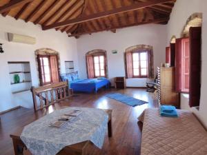 ein Wohnzimmer mit einem blauen Bett und einem Tisch in der Unterkunft vecchia casa in Monemvasia