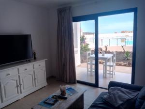 a living room with a television and a table with a view at Apartamento SUN Complex Amaya Fuerteventura in Costa de Antigua