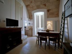 een woonkamer met een eettafel en een televisie bij Suite Sirene in Polignano a Mare