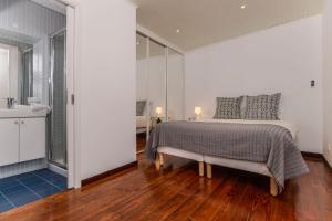 a white bedroom with a bed and a bathroom at Seaside Family Townhouse - 100m from the sea! in Cascais