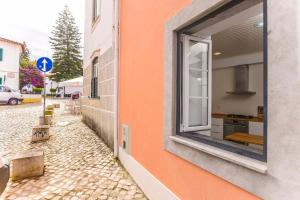 a window on the side of a building at Seaside Family Townhouse - 100m from the sea! in Cascais