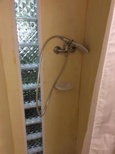 a shower in a bathroom next to a window at Mohatetős Lombház in Üröm