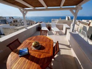 een houten tafel en stoelen op een balkon bij Suite Sirene in Polignano a Mare