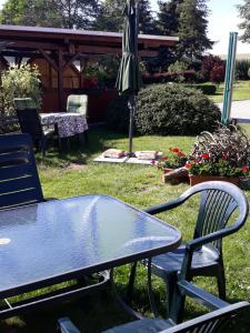 ヒンターヘルムスドルフにあるFewo Hoyerの庭にテーブルと椅子、傘