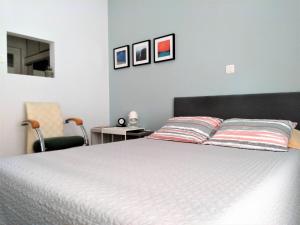 um quarto com uma cama branca e uma cadeira em Athens Pangrati modern apt 10min to metro em Atenas