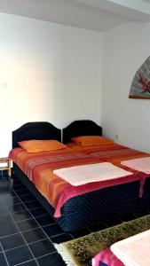 a bedroom with a large bed with orange sheets at Apartman Tatjana in Sutomore