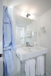 a white bathroom with a sink and a mirror at The Study at Yale, Study Hotels in New Haven