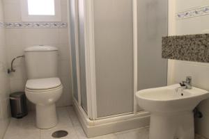 łazienka z toaletą, prysznicem i umywalką w obiekcie Sur Suites Torremolinos w mieście Torremolinos