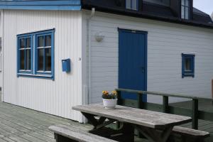 a picnic table in front of a building with a blue door at Fredheimbrygga in Andenes