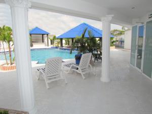 a patio with a table and chairs next to a pool at Hotel Iraqúa in Acacías
