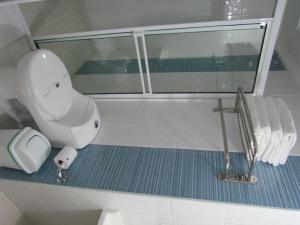 y baño con aseo blanco y espejo. en Hotel Iraqúa, en Acacías