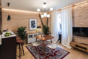 sala de estar con mesa y pared de ladrillo en Miribilla by Staynnapartments, en Bilbao