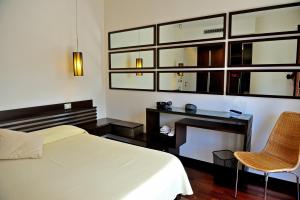 een slaapkamer met een bed, een bureau en een stoel bij Hotel Le Piane in Villammare