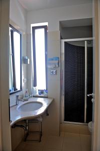 y baño con lavabo y ducha. en Hotel Le Piane, en Villammare
