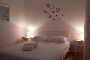 a bedroom with a white bed with two nightstands and two lamps at Petra Apartments in Korčula
