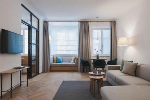Kuntino Suites في ميرانو: غرفة معيشة بها أريكة وجهاز تلفزيون